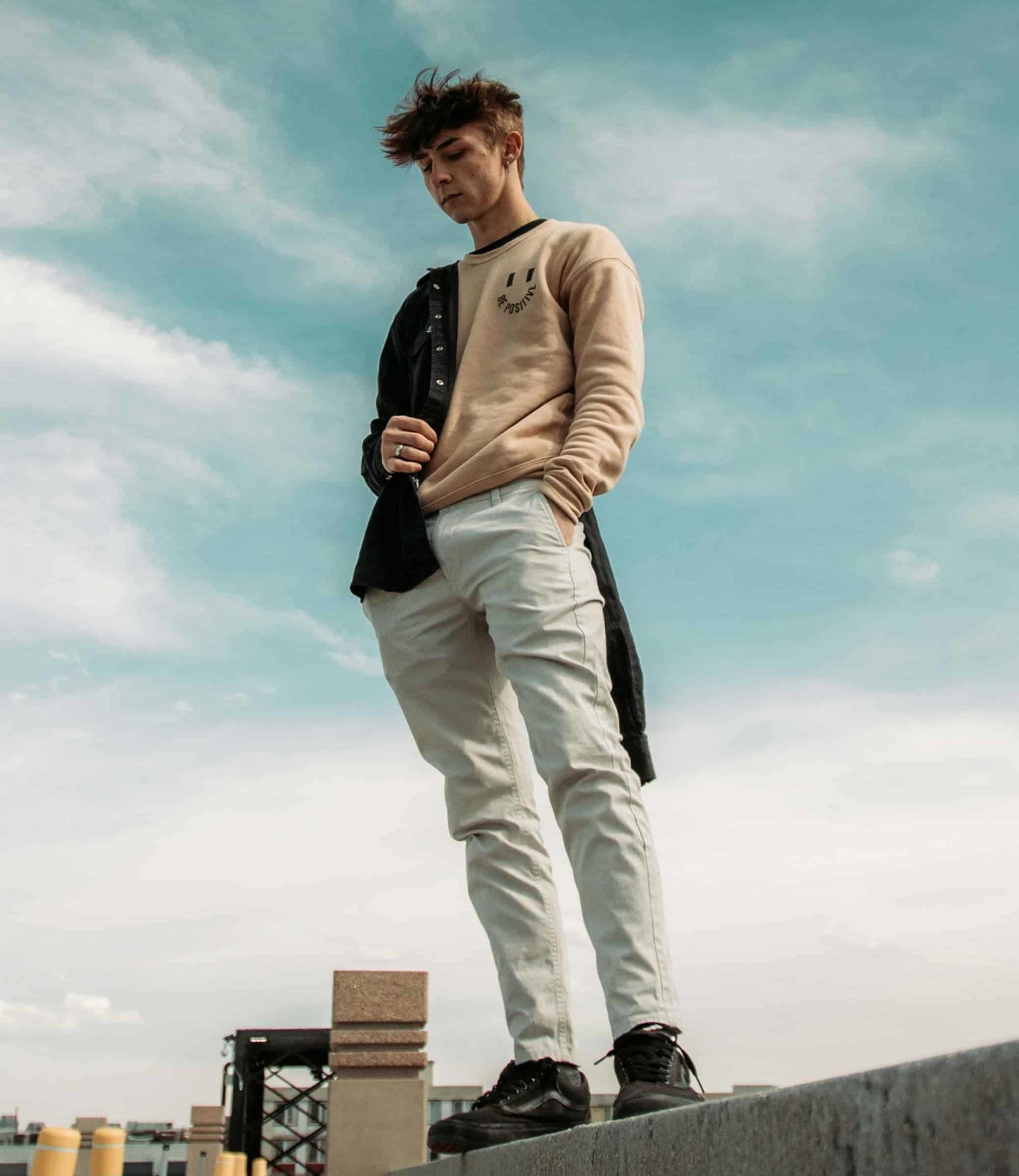 homem com moletom beje, calça jeans branca e tenis preto